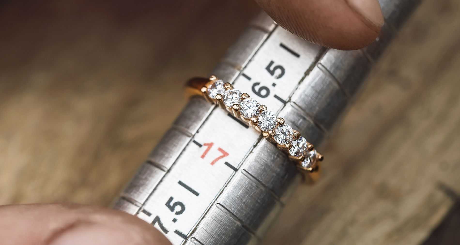 An image of a jeweler sizing a wedding ring.