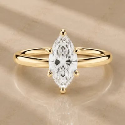 marquise cut solitaire engagement ring on neutral background