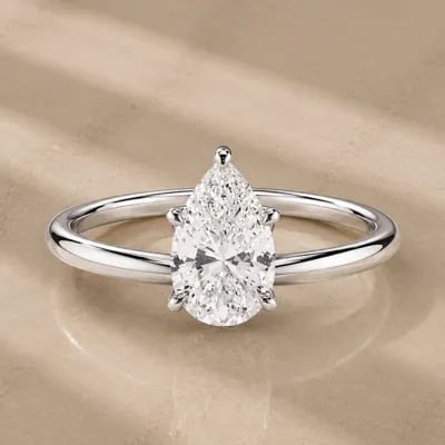 pear cut solitaire engagement ring on neutral background