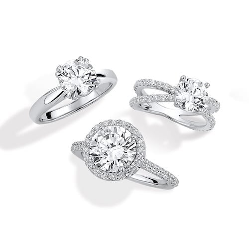 solitaire, sidestone, and halo engagement ring next to each other